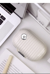Detailed macro view of a creamy white portable pill box with a vertical striped suitcase texture