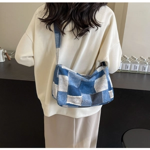 Détail du sac en patchwork de denim à carreaux porté par un mannequin dans un café
