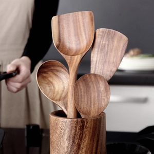 Close-up of acacia wood kitchen utensil set in a matching wooden storage holder
