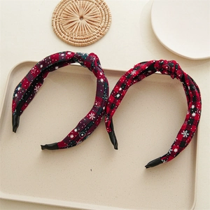 Detail of Christmas plaid knot headbands featuring red and green snowflake patterns