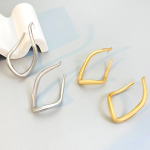 Detailed view of large gold and silver minimalist irregular geometric metal hoop earrings