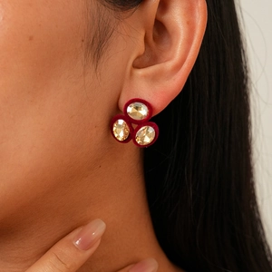 Detailed close-up of vintage oval flocked earrings with crystals on a model's ear