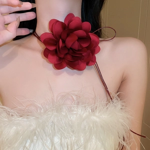 Close-up of deep red fabric camellia flower choker with elegant adjustable cord