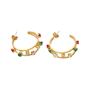 Golden hoop earrings with colorful gemstones and stainless steel post in studio light