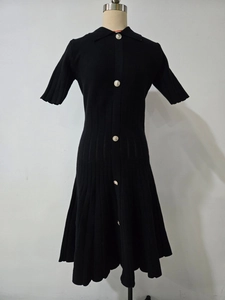 Détail du col polo et des boutons métalliques argentés sur la robe noire en maille