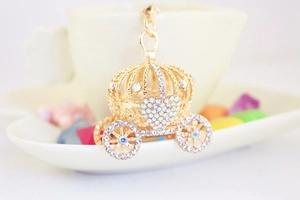 Détail macro d'un porte-clés carrosse de citrouille doré orné de strass étincelants