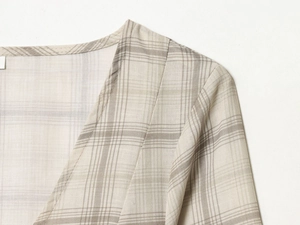 Close-up of V-neck plaid dress showing high-quality cotton-linen texture and fine stitching