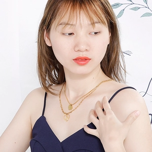 Close-up of a double-layered gold heart necklace showing the hollow pendant on a model neck
