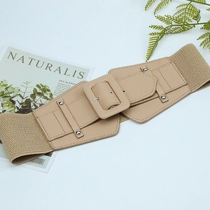 Detail of beige elastic wide waist belt featuring a rectangular buckle and silver studs