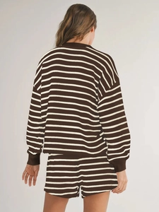 Rear view of woman wearing brown and cream striped long-sleeve knit shirt and shorts set