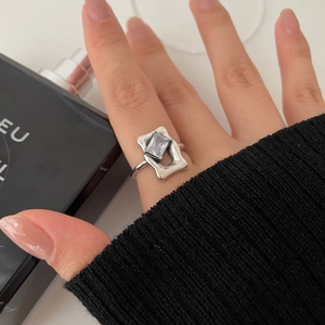 Detail of minimalist 925 silver ring featuring a rectangular gemstone on finger