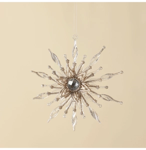 Detailed close-up of a snowflake ornament with a grey gemstone and golden glitter accents