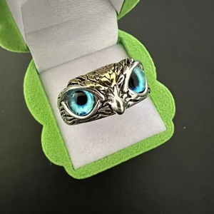 Macro detail of retro owl ring with blue eyes and silver antique finish texture
