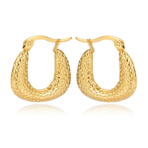 Detail shot of golden hammered texture on stainless steel U-shaped hoop earrings