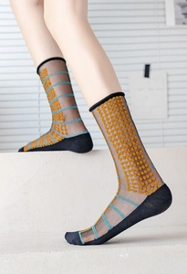 Macro detail of sheer crew socks with orange polka dots and blue stripe accents