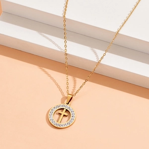 Macro detail of golden cross necklace with crystal circle pendant and sharp shadows