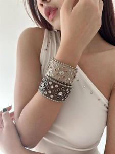 Close-up of beige and brown leather bracelets with rhinestones in bohemian and rock style