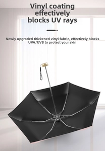 Detail of pink sun umbrella with black vinyl coating and gold handle for UV protection