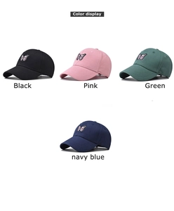 Détail de quatre casquettes de baseball en coton brodées de papillons en plusieurs couleurs