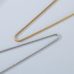 Detail der gewebten Weizenketten in Gold und Silber mit polierter Metallstruktur