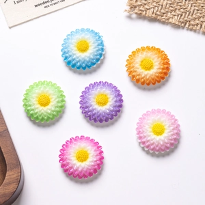 Close-up of colorful resin daisy flower charms for DIY crafts on a clean white background