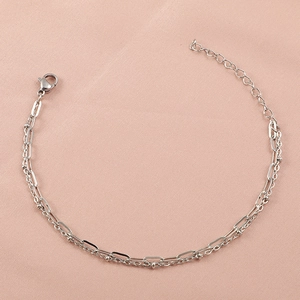 Detail of silver double-layered stainless steel bracelet with oval links and bead chain