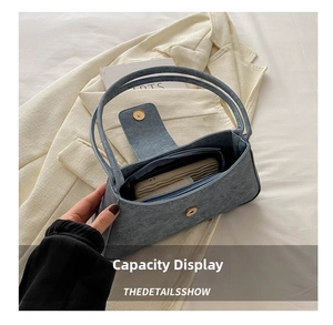 Detailed view of the blue denim baguette bag interior showing the spacious main compartment
