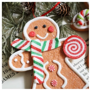 Detailed macro shot of a resin gingerbread man ornament with red scarf and candy cane