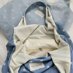 Détail du sac cabas en denim à imprimé étoiles avec poche zippée et doublure en tissu