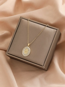Close-up of Virgin Mary pendant with colorful zircon stones on gold necklace
