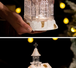 Detailed view of glowing Christmas church snow globe with shimmering glitter and golden top