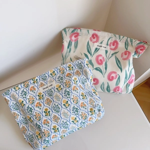 Détail de trousses de maquillage en coton avec fleurs de tulipes et motifs géométriques