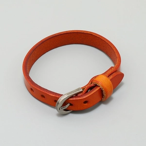 Close-up of vibrant orange leather strap with adjustable metal buckle and natural texture