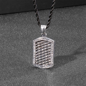 Close-up of punk style shield pendant with woven texture and sparkling zirconia accents