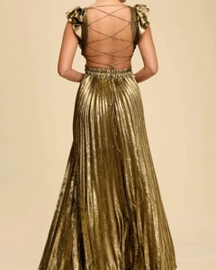 Detail of gold backless pleated dress featuring elegant crisscross lace-up straps