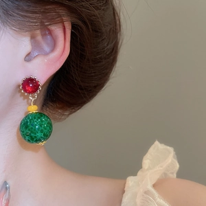 Close-up of vintage resin drop earrings with red, yellow, and green textured beads