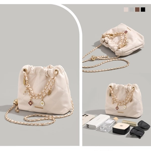 Quilted off-white chain bucket bag with heart charms and daily items for capacity reference