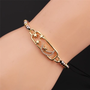 Detail of tricolor gold beaded bracelet featuring a sparkling zircon star and moon frame