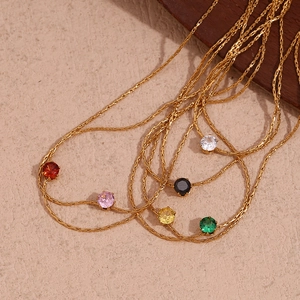 Macro view of dainty 18K gold plated chains featuring colorful zircon pendant charms