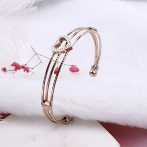 Close-up of rose gold stainless steel cuff bracelet with hollow heart and zircon inlay