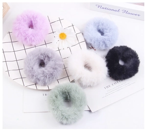 Flat lay of plush faux fur hair ties in purple, blue, grey, white, black and green