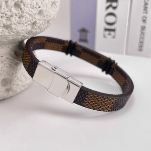 Detail of a brown checkered leather bracelet with a polished silver metal clasp