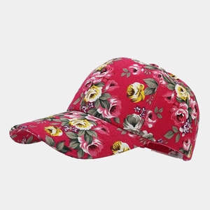 Detailed macro view of vintage canvas baseball cap with red floral rose pattern print