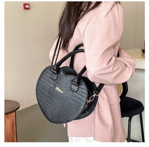 Sac à main noir en forme de cœur avec motif crocodile et détails de bandoulière dorés
