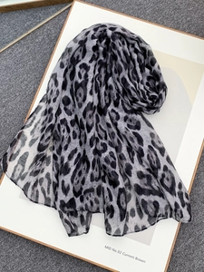 Detail view of leopard print chiffon scarf showing light fabric and edge stitching