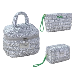 Three-piece silver quilted makeup bag set with premium metallic finish and green logo detail