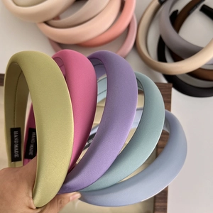 Macro shot of colorful satin sponge headbands showing thick texture and handmade labels