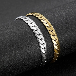 Makroaufnahme polierter goldener und silberner Panzerarmbänder auf schwarzem Grund