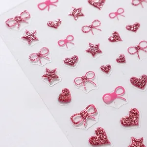 Detailed view of pink glitter nail stickers featuring stars, hearts, and bow patterns