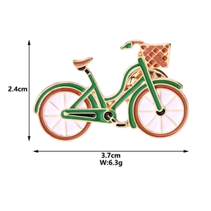 Detail showing green bicycle enamel brooch dimensions 3.7cm by 2.4cm and 6.3g weight